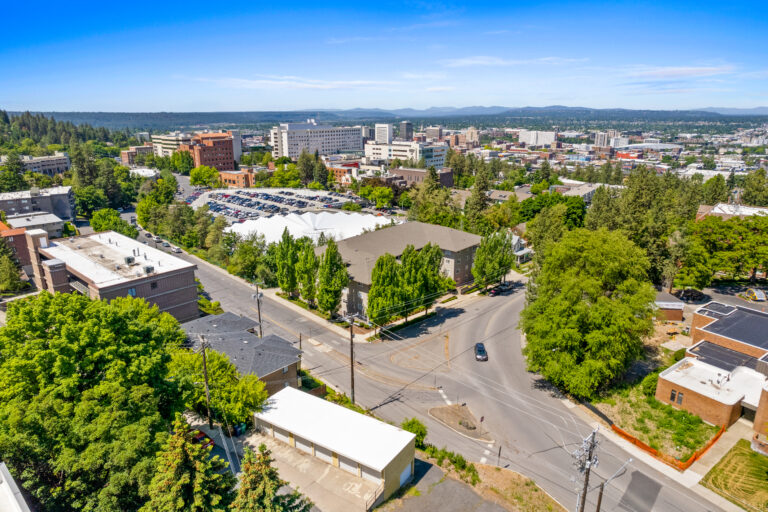Aerial cityscape with buildings, greenery, and roads, ideal for real estate photography and property marketing.